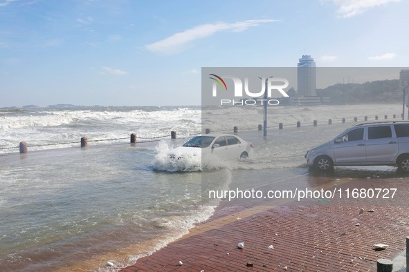 Cars pass a road covered with seawater at the seaside in Yantai, China, on October 19, 2024. 