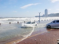 Cars pass a road covered with seawater at the seaside in Yantai, China, on October 19, 2024. (