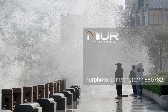 Tourists watch waves at the seaside in Yantai, China, on October 19, 2024. 