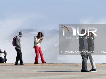 Tourists watch waves at the seaside in Yantai, China, on October 19, 2024. (