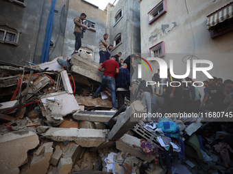 Palestinians inspect the damage to a building following Israeli bombardment in the Maghazi camp for Palestinian refugees in the central Gaza...