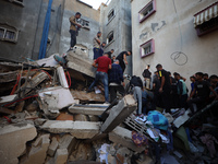 Palestinians inspect the damage to a building following Israeli bombardment in the Maghazi camp for Palestinian refugees in the central Gaza...