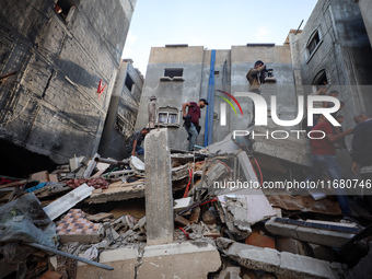 Palestinians inspect the damage to a building following Israeli bombardment in the Maghazi camp for Palestinian refugees in the central Gaza...