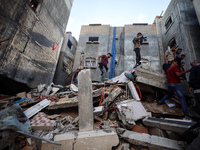 Palestinians inspect the damage to a building following Israeli bombardment in the Maghazi camp for Palestinian refugees in the central Gaza...