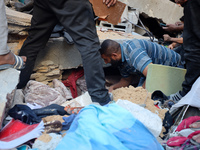 Palestinians inspect the damage to a building following Israeli bombardment in the Maghazi camp for Palestinian refugees in the central Gaza...