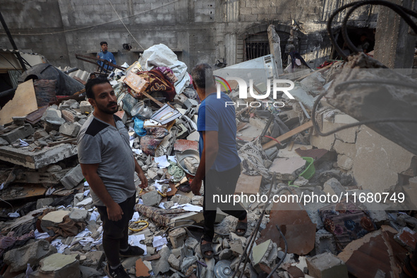 Palestinians inspect the damage to a building following Israeli bombardment in the Maghazi camp for Palestinian refugees in the central Gaza...