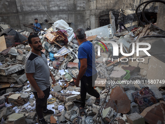 Palestinians inspect the damage to a building following Israeli bombardment in the Maghazi camp for Palestinian refugees in the central Gaza...