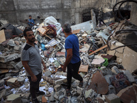 Palestinians inspect the damage to a building following Israeli bombardment in the Maghazi camp for Palestinian refugees in the central Gaza...