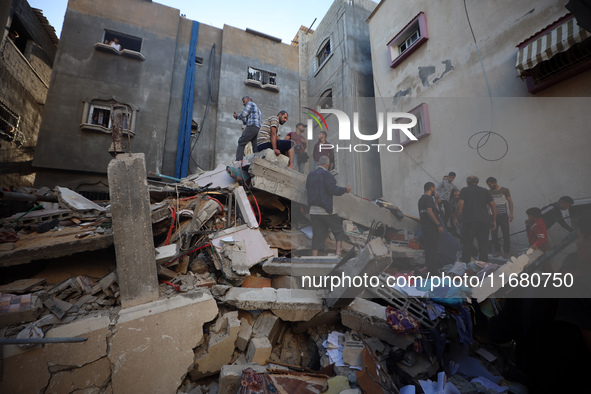 Palestinians inspect the damage to a building following Israeli bombardment in the Maghazi camp for Palestinian refugees in the central Gaza...