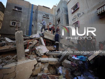 Palestinians inspect the damage to a building following Israeli bombardment in the Maghazi camp for Palestinian refugees in the central Gaza...