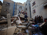 Palestinians inspect the damage to a building following Israeli bombardment in the Maghazi camp for Palestinian refugees in the central Gaza...