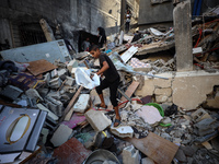 Palestinians inspect the damage to a building following Israeli bombardment in the Maghazi camp for Palestinian refugees in the central Gaza...