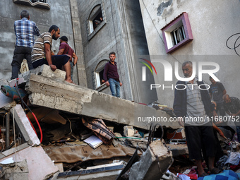 Palestinians inspect the damage to a building following Israeli bombardment in the Maghazi camp for Palestinian refugees in the central Gaza...