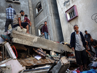 Palestinians inspect the damage to a building following Israeli bombardment in the Maghazi camp for Palestinian refugees in the central Gaza...