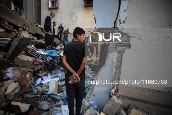 Palestinians inspect the damage to a building following Israeli bombardment in the Maghazi camp for Palestinian refugees in the central Gaza...