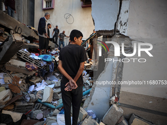 Palestinians inspect the damage to a building following Israeli bombardment in the Maghazi camp for Palestinian refugees in the central Gaza...