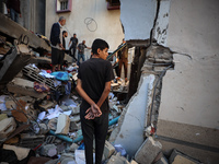 Palestinians inspect the damage to a building following Israeli bombardment in the Maghazi camp for Palestinian refugees in the central Gaza...