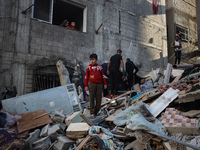 Palestinians inspect the damage to a building following Israeli bombardment in the Maghazi camp for Palestinian refugees in the central Gaza...