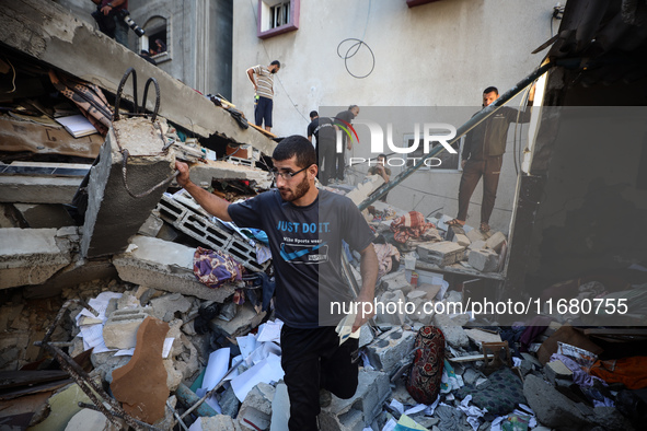 Palestinians inspect the damage to a building following Israeli bombardment in the Maghazi camp for Palestinian refugees in the central Gaza...