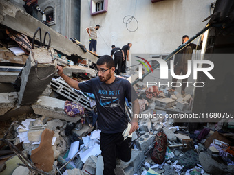 Palestinians inspect the damage to a building following Israeli bombardment in the Maghazi camp for Palestinian refugees in the central Gaza...