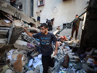 Palestinians inspect the damage to a building following Israeli bombardment in the Maghazi camp for Palestinian refugees in the central Gaza...