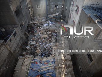 Palestinians inspect the damage to a building following Israeli bombardment in the Maghazi camp for Palestinian refugees in the central Gaza...