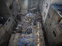 Palestinians inspect the damage to a building following Israeli bombardment in the Maghazi camp for Palestinian refugees in the central Gaza...