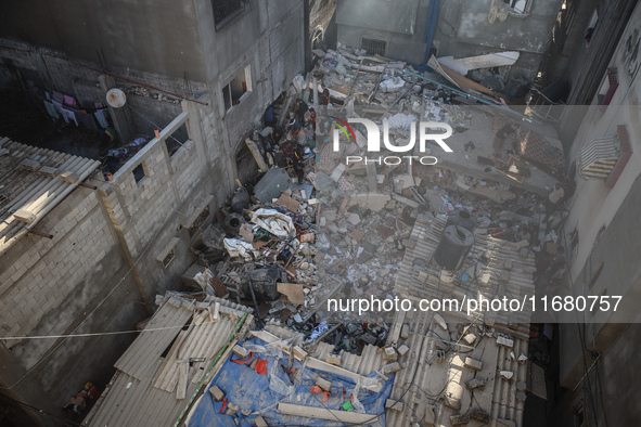 Palestinians inspect the damage to a building following Israeli bombardment in the Maghazi camp for Palestinian refugees in the central Gaza...