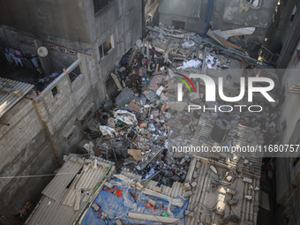 Palestinians inspect the damage to a building following Israeli bombardment in the Maghazi camp for Palestinian refugees in the central Gaza...