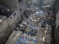 Palestinians inspect the damage to a building following Israeli bombardment in the Maghazi camp for Palestinian refugees in the central Gaza...