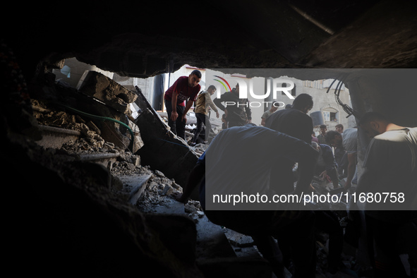 Palestinians inspect the damage to a building following Israeli bombardment in the Maghazi camp for Palestinian refugees in the central Gaza...