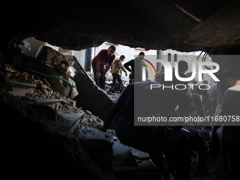 Palestinians inspect the damage to a building following Israeli bombardment in the Maghazi camp for Palestinian refugees in the central Gaza...