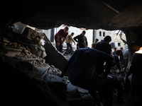 Palestinians inspect the damage to a building following Israeli bombardment in the Maghazi camp for Palestinian refugees in the central Gaza...