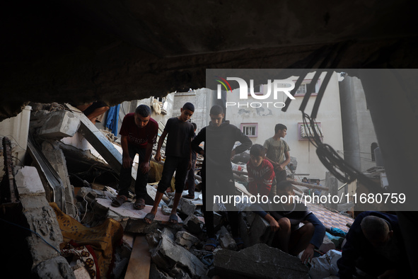 Palestinians inspect the damage to a building following Israeli bombardment in the Maghazi camp for Palestinian refugees in the central Gaza...