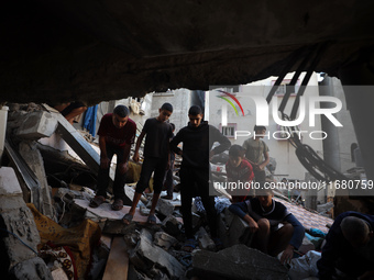 Palestinians inspect the damage to a building following Israeli bombardment in the Maghazi camp for Palestinian refugees in the central Gaza...