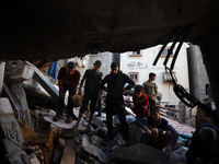 Palestinians inspect the damage to a building following Israeli bombardment in the Maghazi camp for Palestinian refugees in the central Gaza...