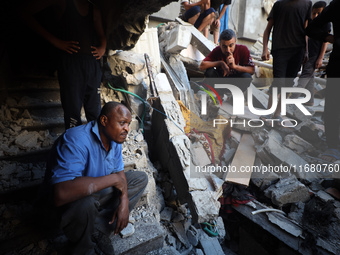 Palestinians inspect the damage to a building following Israeli bombardment in the Maghazi camp for Palestinian refugees in the central Gaza...