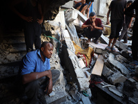 Palestinians inspect the damage to a building following Israeli bombardment in the Maghazi camp for Palestinian refugees in the central Gaza...