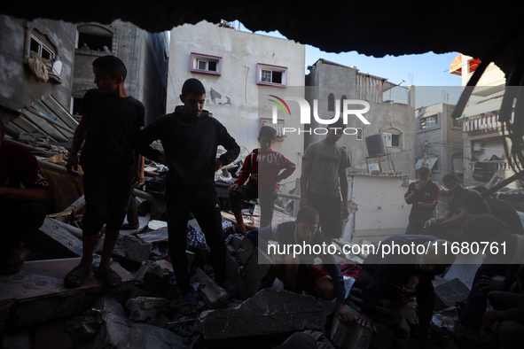 Palestinians inspect the damage to a building following Israeli bombardment in the Maghazi camp for Palestinian refugees in the central Gaza...