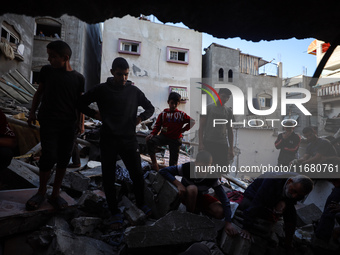 Palestinians inspect the damage to a building following Israeli bombardment in the Maghazi camp for Palestinian refugees in the central Gaza...