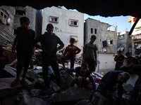 Palestinians inspect the damage to a building following Israeli bombardment in the Maghazi camp for Palestinian refugees in the central Gaza...