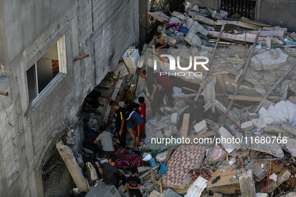 Palestinians inspect the damage to a building following Israeli bombardment in the Maghazi camp for Palestinian refugees in the central Gaza...