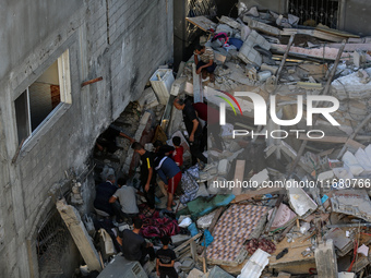 Palestinians inspect the damage to a building following Israeli bombardment in the Maghazi camp for Palestinian refugees in the central Gaza...