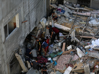 Palestinians inspect the damage to a building following Israeli bombardment in the Maghazi camp for Palestinian refugees in the central Gaza...