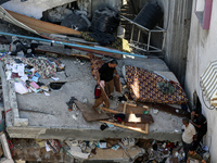 Palestinians inspect the damage to a building following Israeli bombardment in the Maghazi camp for Palestinian refugees in the central Gaza...