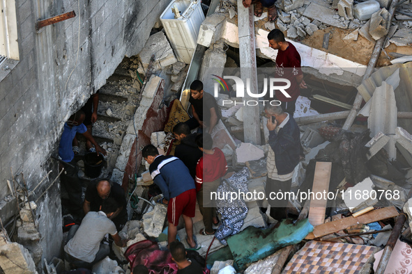 Palestinians inspect the damage to a building following Israeli bombardment in the Maghazi camp for Palestinian refugees in the central Gaza...