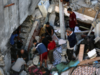 Palestinians inspect the damage to a building following Israeli bombardment in the Maghazi camp for Palestinian refugees in the central Gaza...