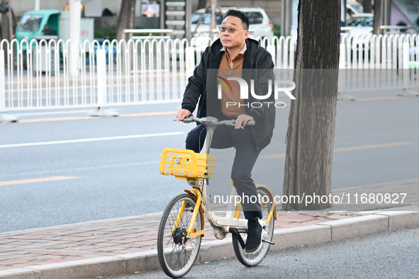 A citizen rides in thick clothes as temperatures plummet in Beijing, China, on October 19, 2024. 