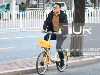 A citizen rides in thick clothes as temperatures plummet in Beijing, China, on October 19, 2024. (