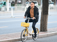 A citizen rides in thick clothes as temperatures plummet in Beijing, China, on October 19, 2024. (